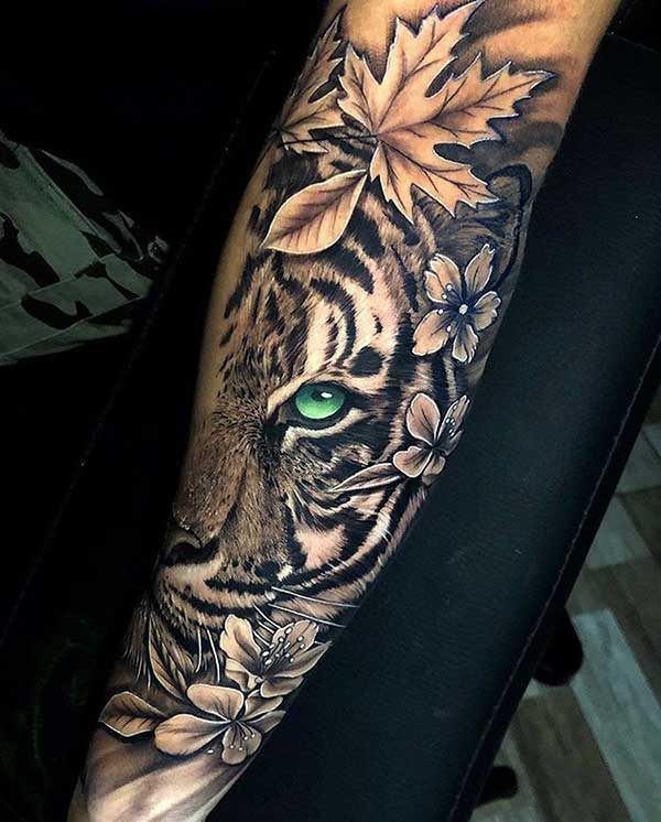 no Braco 0 Tatuagem de onça onde o verde do olho cria um grande contraste com a tinta preta resultando em uma obra de arte.